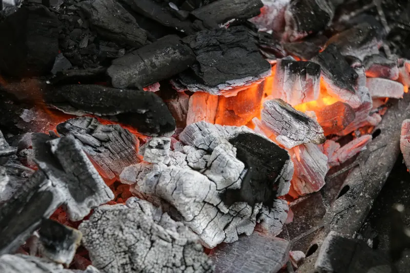 Close-up of glowing charcoal embers with vivid heat and texture, ideal for barbecue themes